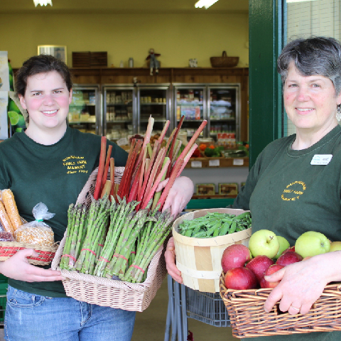 Burnham Farm market staff holding baskets of produce