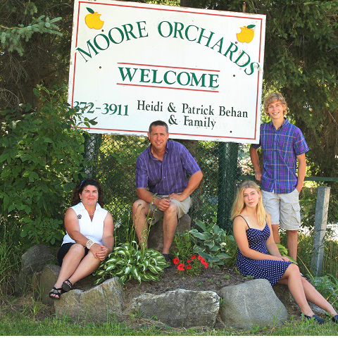 The Moore's Orchards family at their farm sign